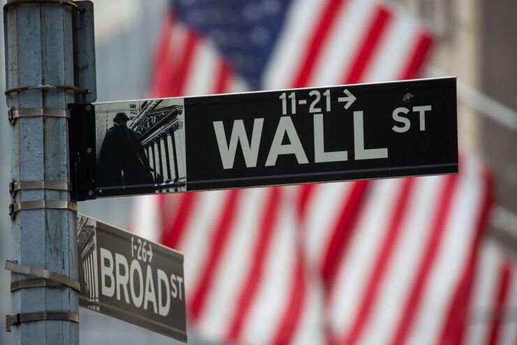 A Wall Street and Broad Street street sign in front of the New York Stock Exchange in New York