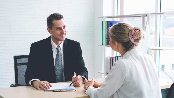 Woman being interviewed for job facing male interviewer