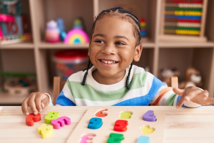 A young boy playing with a math puzzle game.