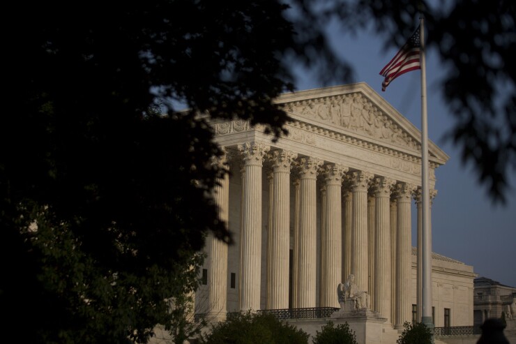The American flag flies next to the U.S. Supreme Court in Washington, D.C.