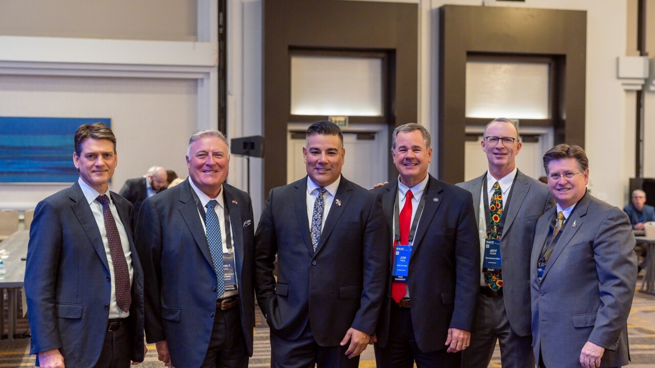 Insurance commissioners standing in a row at conference