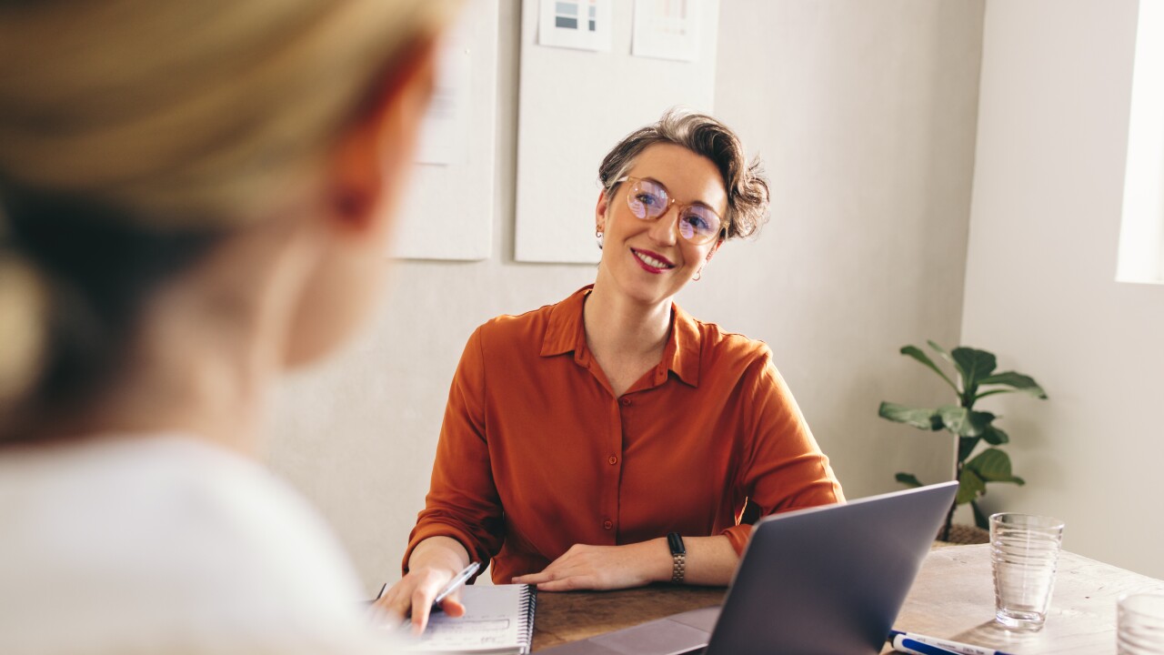 Happy hiring manager interviewing a job candidate in her office