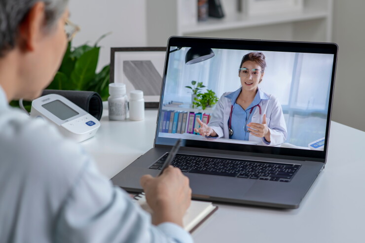 Woman talking with doctor, virtual appointment on laptop