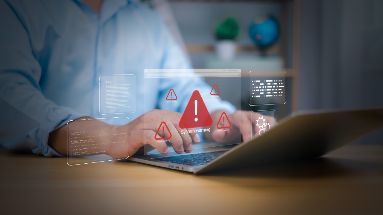 A person using a laptop with five holographic images of warnings sign and text boxes.