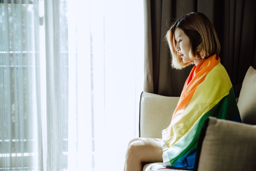 Asian girl and rainbow flag, Young lesbian sit alone in living room