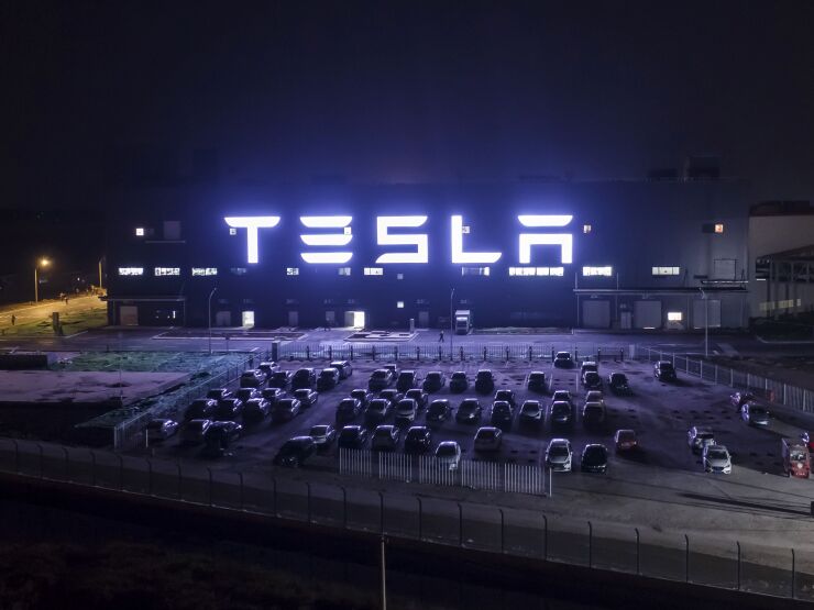 Tesla sign illuminated at night.