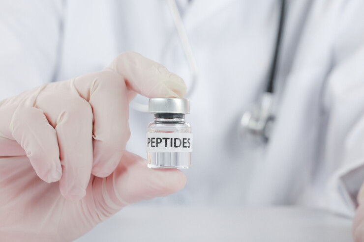 Doctor holding peptide vial inside a wellness clinic