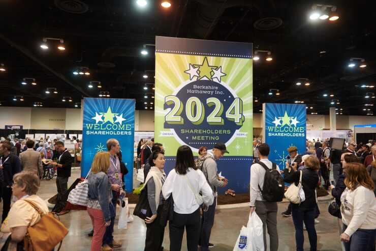 Attendees in front of a 2024 sign at a shareholders shopping day ahead of the Berkshire Hathaway annual shareholders meeting.