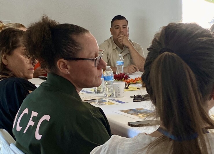 Commissioner Ricardo Lara listens to Altadena residents at table with him