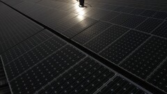 A maintenance worker cleans solar panels at a power station in New Delhi, India.