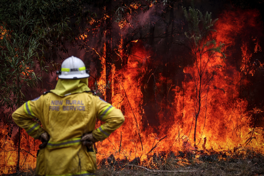A New South Wales (NSW) Rural Fire Service volunteer watches a fire in bushland during back-burning operations in bushland near the town of Kulnura, New South Wales, Australia, on Thursday, Dec. 12, 2019.