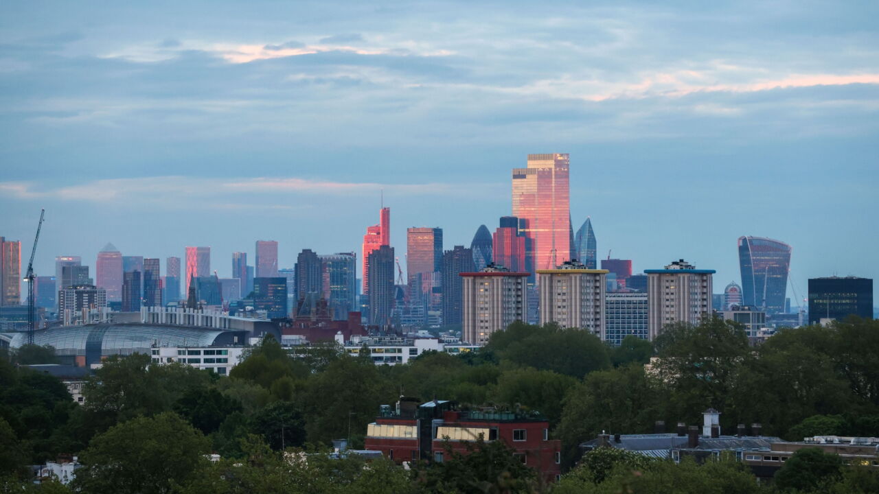 Skyscrapers in the City of London, right, and the Canary Wharf business, financial and shopping district, left, ahead of the supermoon in London, U.K., on Wednesday, May 26, 2021. A supermoon is when a full moon occurs at the closest point to Earth during its orbit, making it appear larger and brighter.