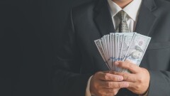 business man wearing suit and necktie holding money in hand on b