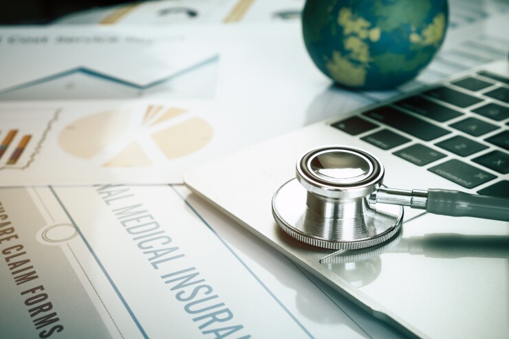 Stethoscope on computer with international medical insurance, he