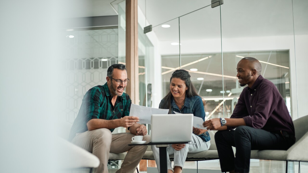 Casual meeting of smiling diverse business team analyzing financ