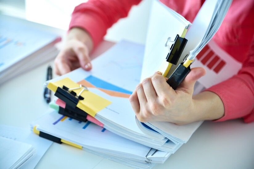 Woman looking through stacks of paperwork