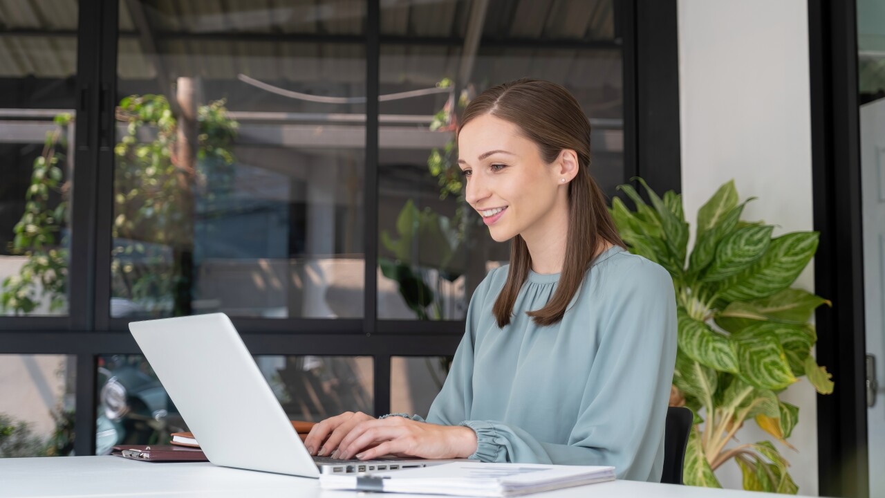 Woman sitting at table working on laptop