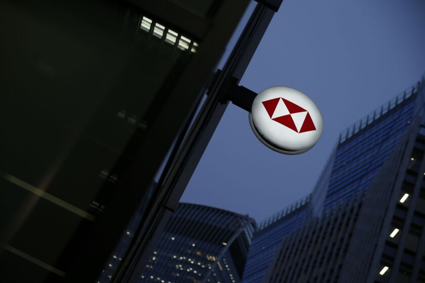 A sign featuring a HSBC logo hangs outside a bank branch in London.