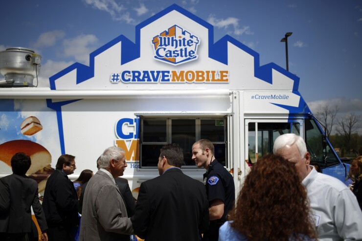 Attendees of the grand opening for the new White Castle Co. Distributing Plant stand in line at the White Caste Cravemobile food truck in Vandalia, Ohio.
