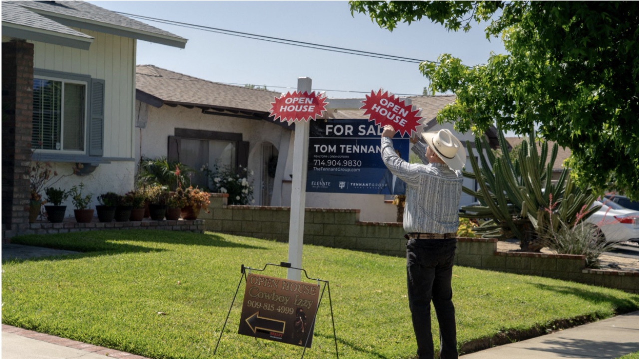 A picture of a realtor putting up signs for an open house outside a home in Rancho Cucamonga, California.