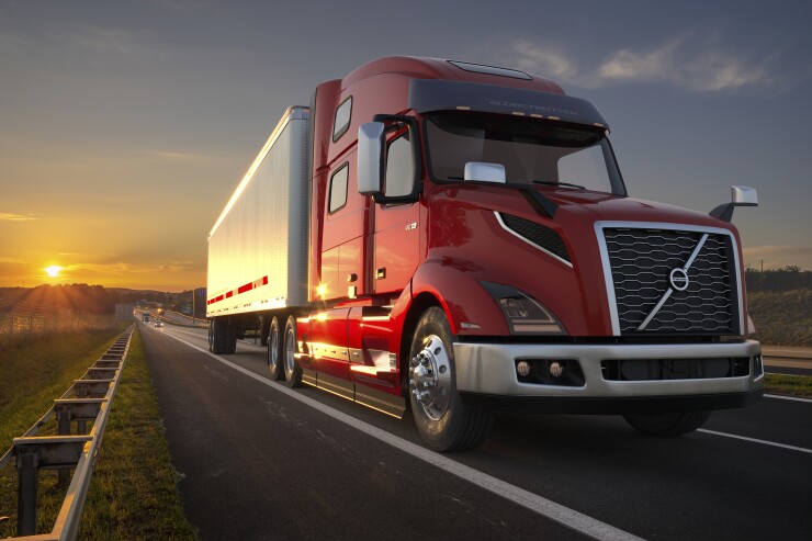 A red Volvo VLN Series truck on a road