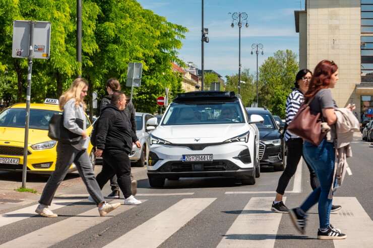 Pedestrians crossing intersection in front of robotaxi
