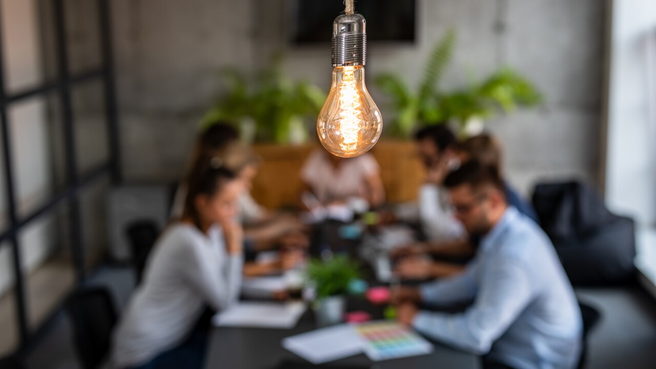 Light bulb over a business meeting