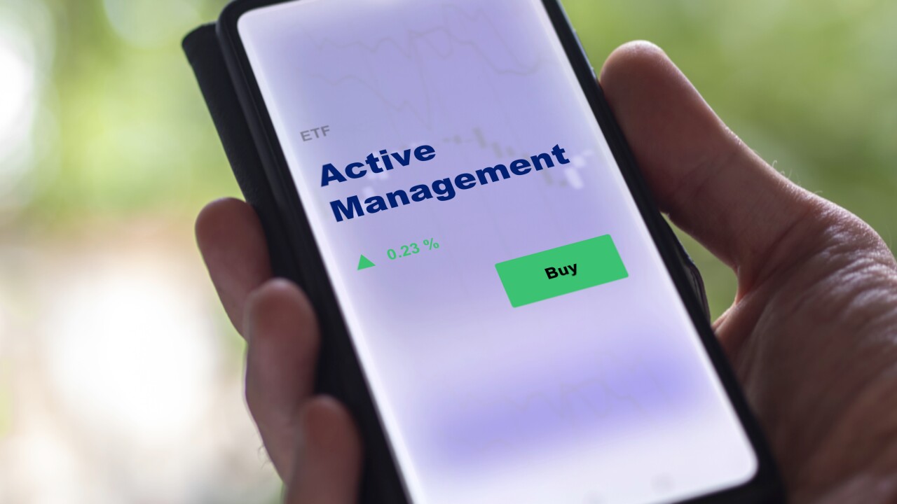A hand holds a smartphone displaying an "Active Management" ETF