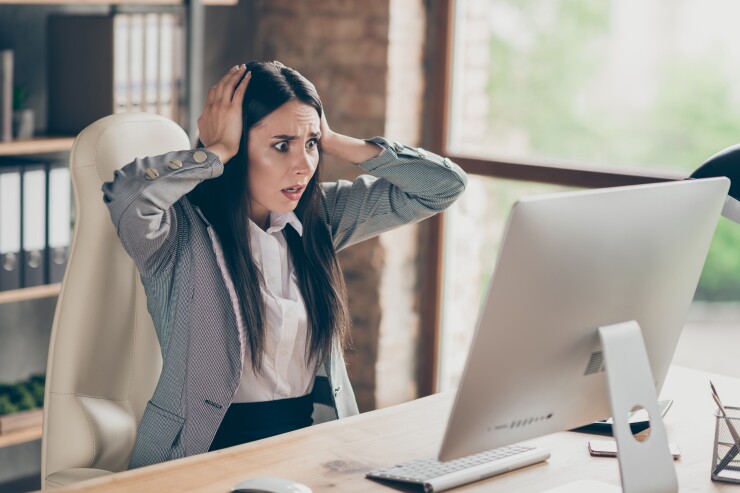 Woman scared, looking at computer, hands on head