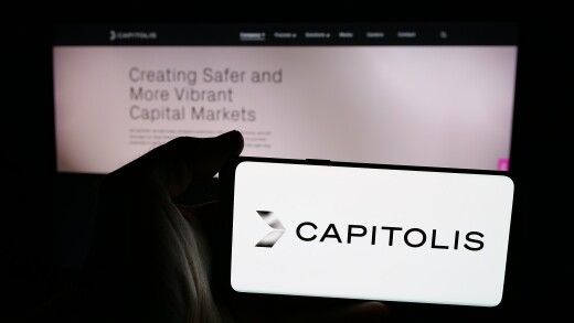 Stuttgart, Germany - 10-31-2024: Person holding mobile phone with logo of US fintech company Capitolis Inc. on screen in front of business web page. Focus on phone display.