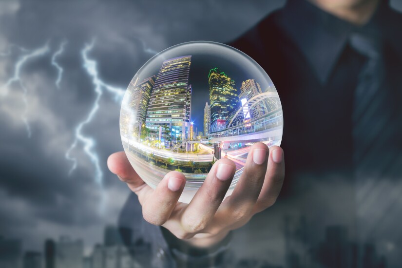 businessman hand hold crystal ball with city night inside with storm and lightning background