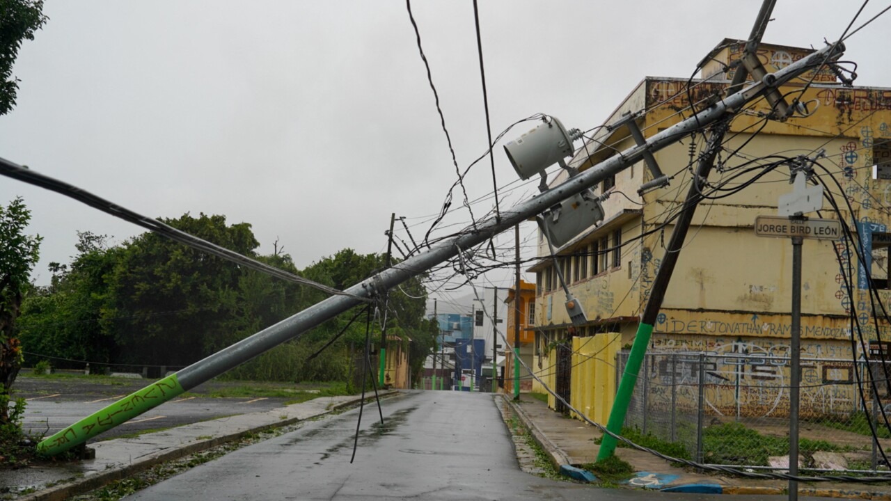 Broken electricity lines above homes damaged after Tropical Storm Ernesto