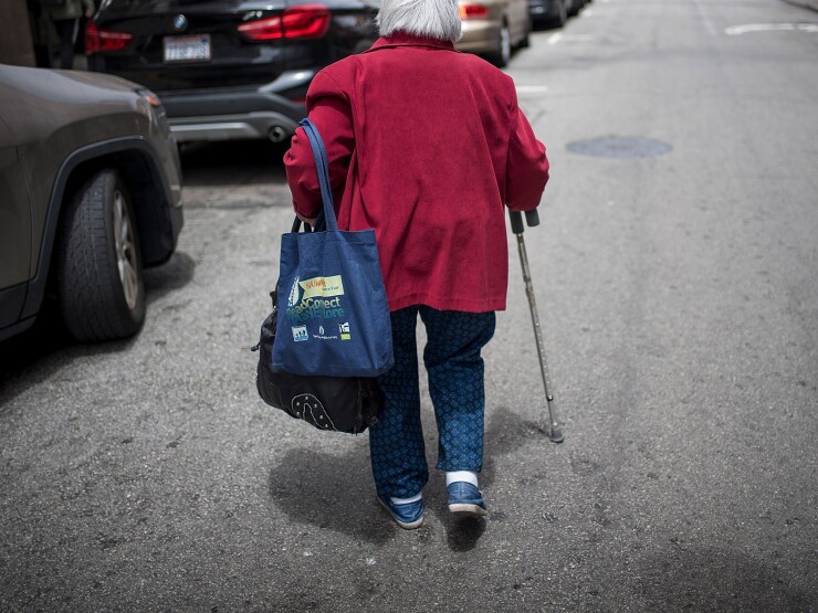 A photo of an elderly woman walking with a cane