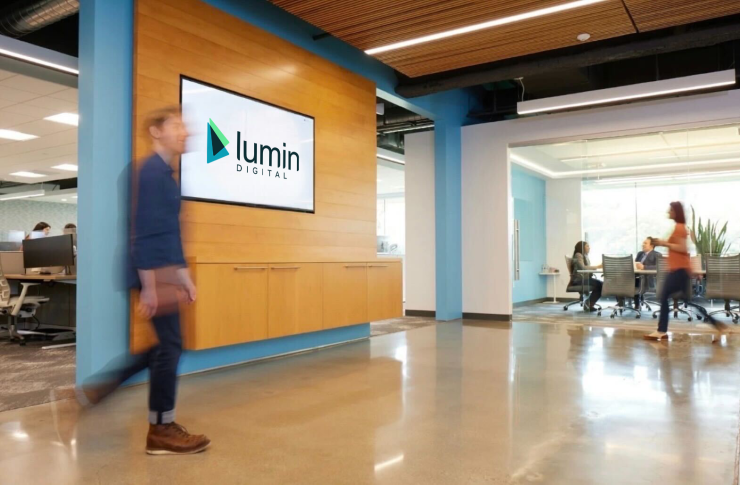Photo of indoor office for Lumin Digital Headquarters with logo on the wall and people walking around