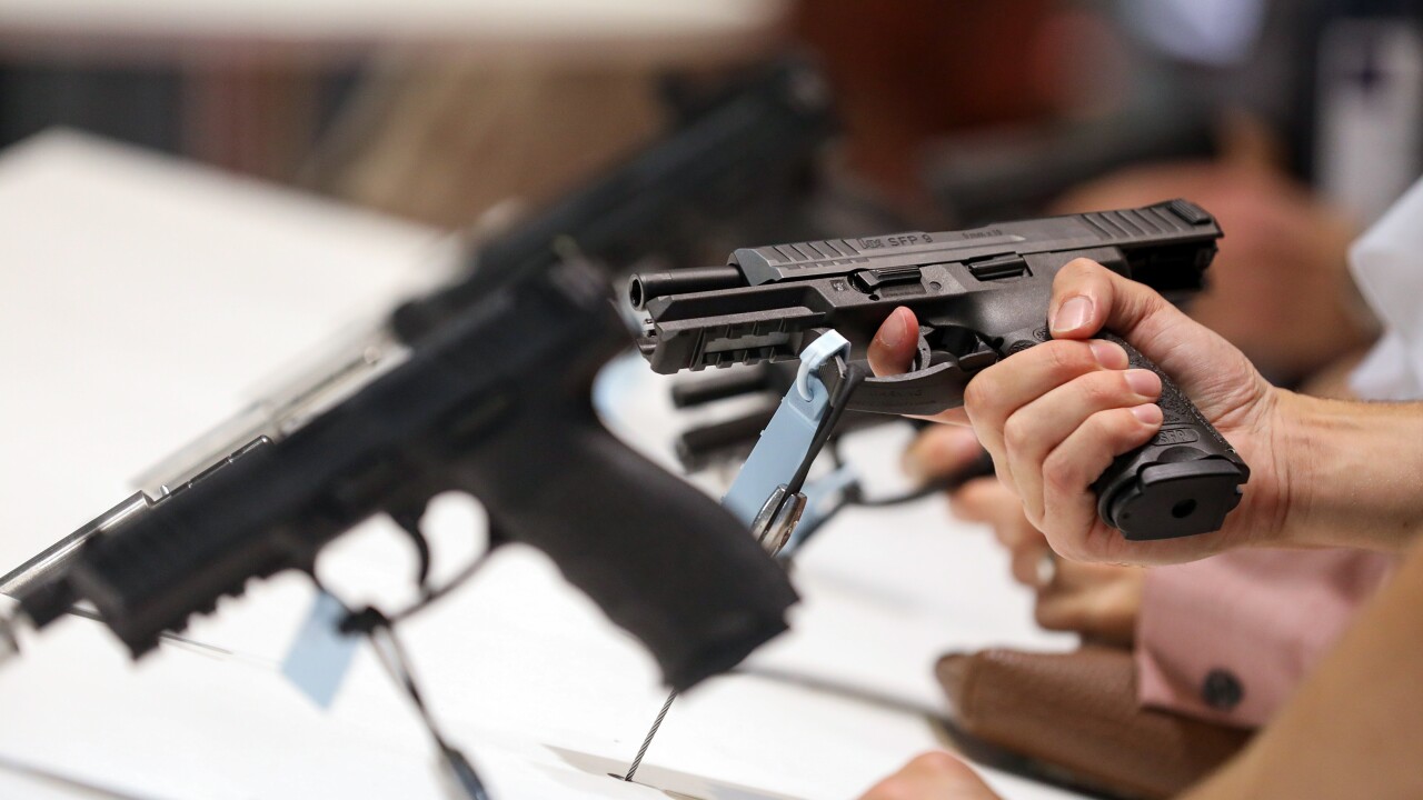 An attendee holds a pistol during the Defense and Security Equipment International exhibition at Excel in London.