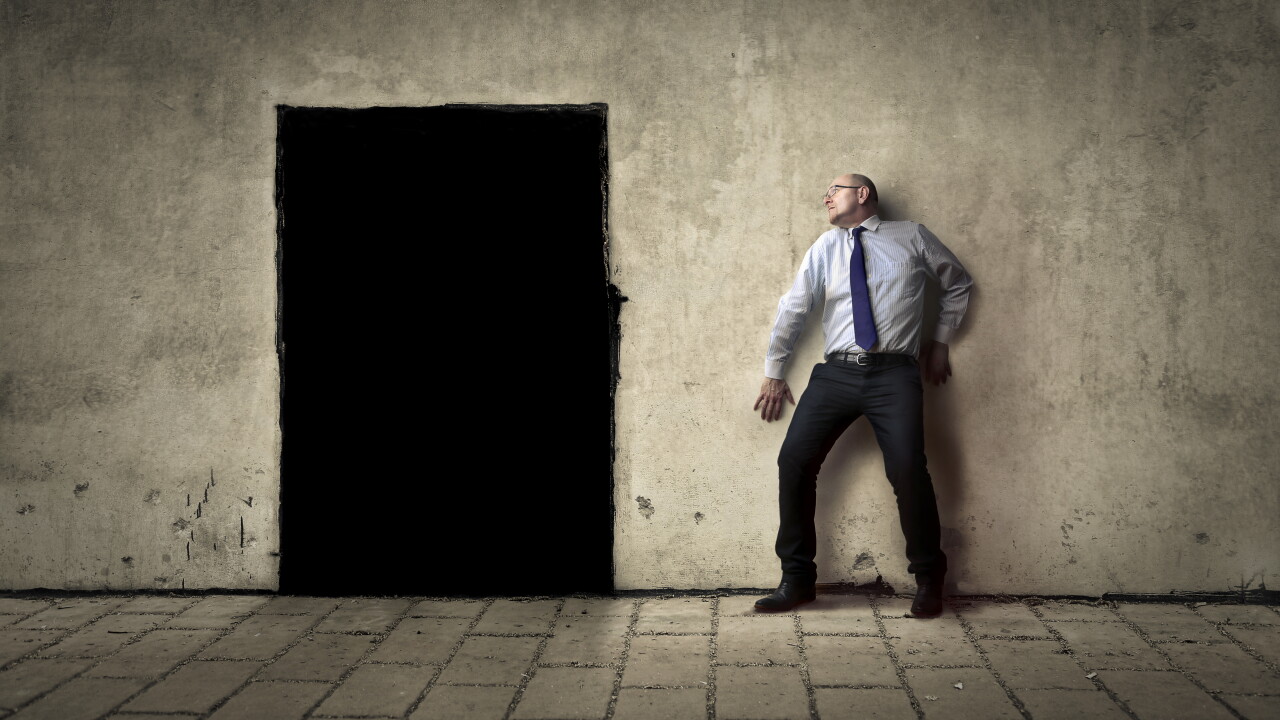 Businessman afraid of black doorway