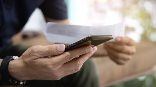 Close up Man checklist using bank of credit card by mobile phone and pay bills in the office