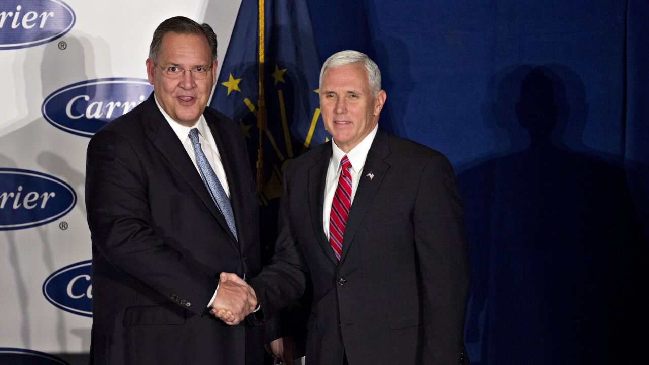 Gregory Hayes, president and chief executive officer of United Technologies Corp., left, shakes hands with U.S. Vice President-elect Mike Pence during an event at Carrier Corp. in Indianapolis, Indiana, U.S., on Thursday, Dec. 1, 2016.