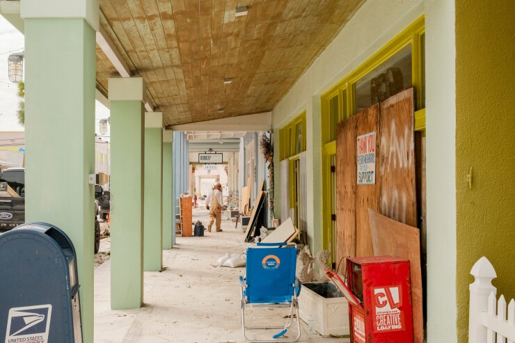 A worker cleans up damage caused by hurricanes Helene and Milton in St. Pete Beach, Florida.