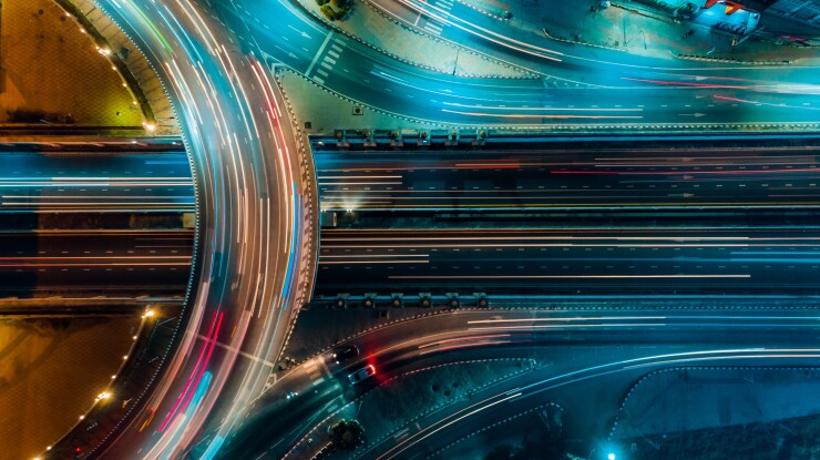 An aerial view of an expressway with light streaks from road traffic.
