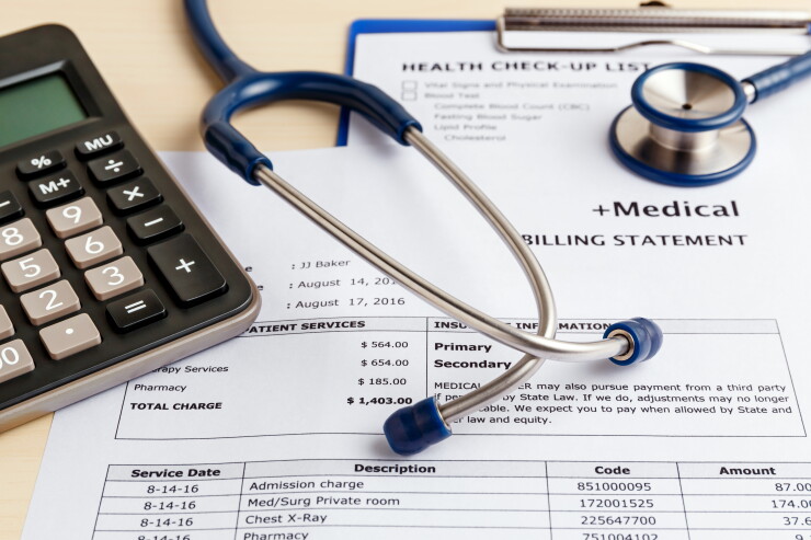 Medical cost concept with calculator and stethoscope.