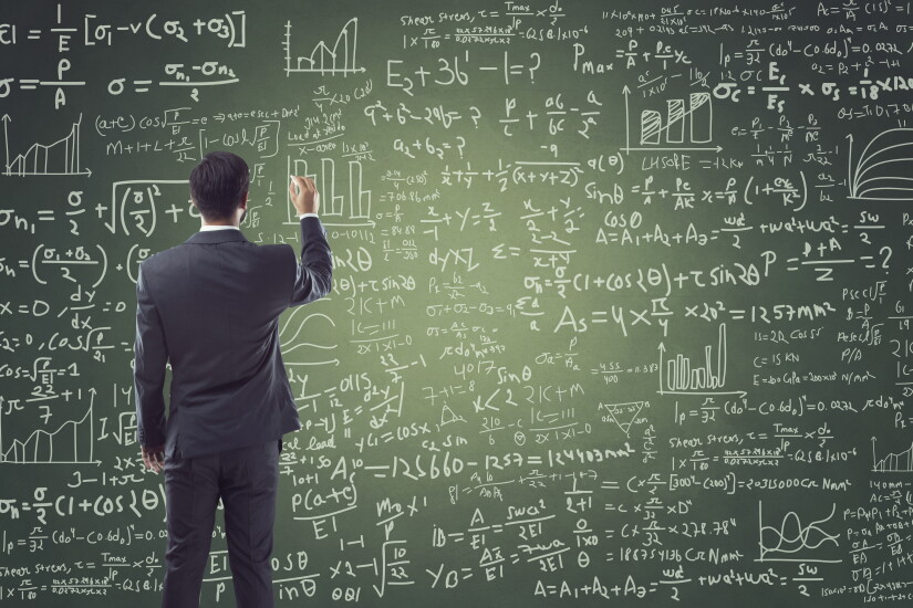 Portrait of a businessman writing on a blackboard. Looks like he is teaching something.