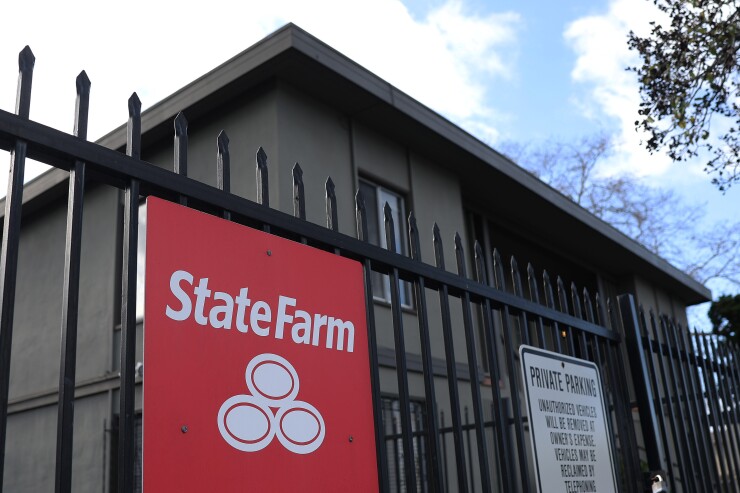 A State Farm sign on a fence.