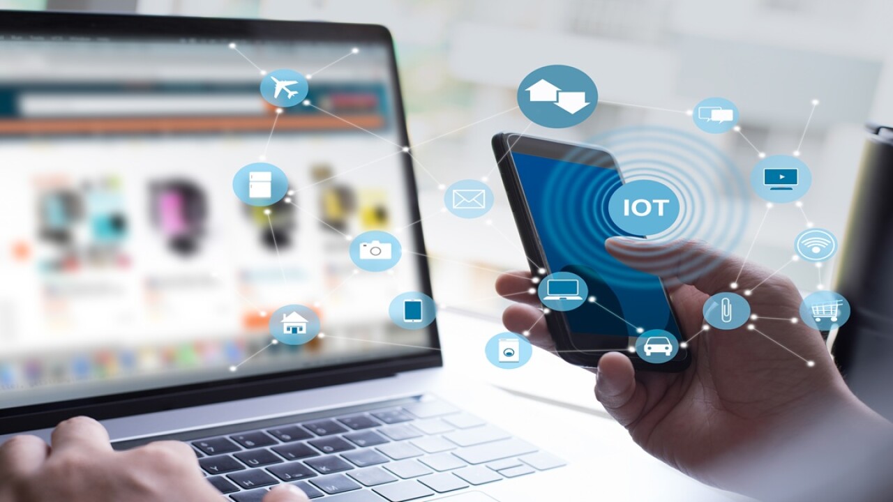 Person on a cell phone and in front of a computer.