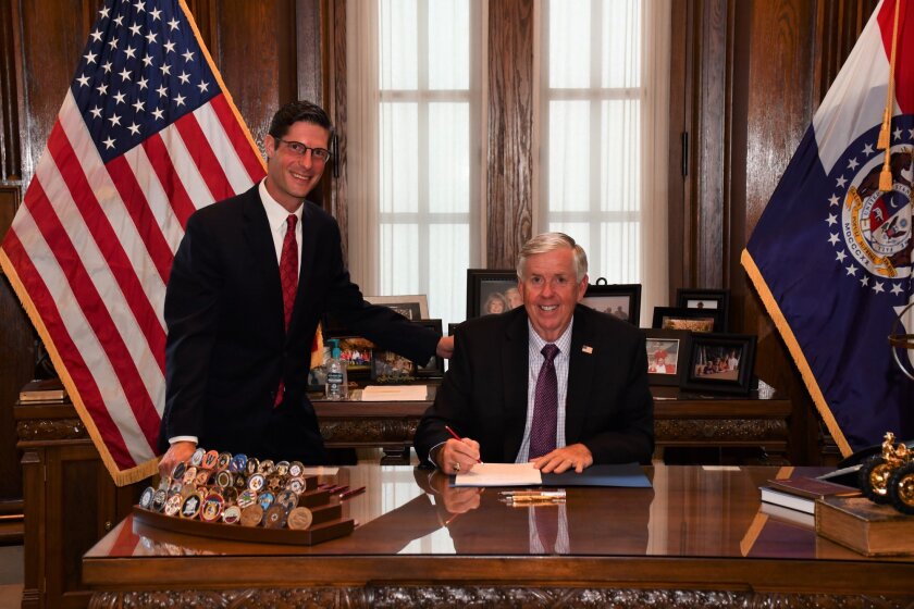 Missouri Gov. Mike Parson, right, signs into law a bill to modernize the Missouri Credit Union Act during a private bill-signing ceremony. He is pictured with Rep. Jack Bondon, one of the bill's cosponsors.
