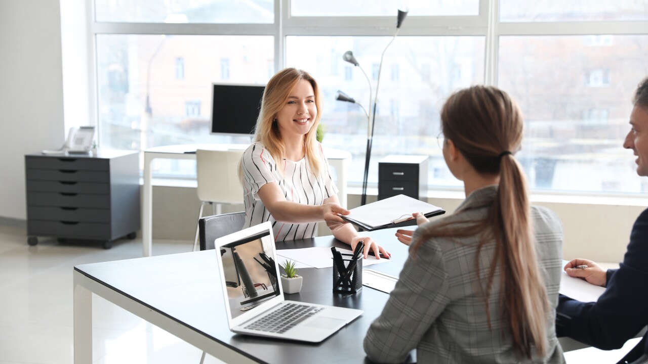 Young woman handing papers in job interview