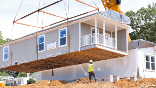 Crane lowering a section of a manufactured home