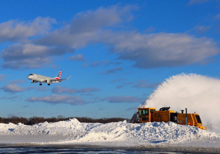 A plane lands amid snow removal operations at Hartford's Bradley International Airport in February 2017.
