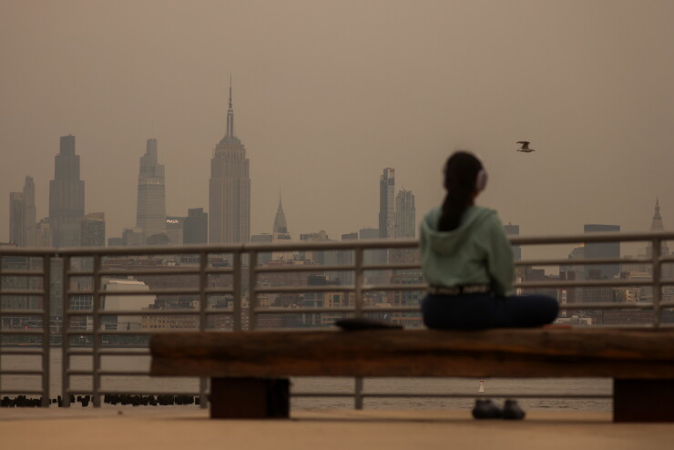 Smoke from wildfires in Canada shrouds the Manhattan skyline at sunrise in Jersey City on July 16.