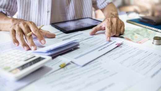 Asian man review business loan application and checking funds in passbook before apply for loan approval to start new business